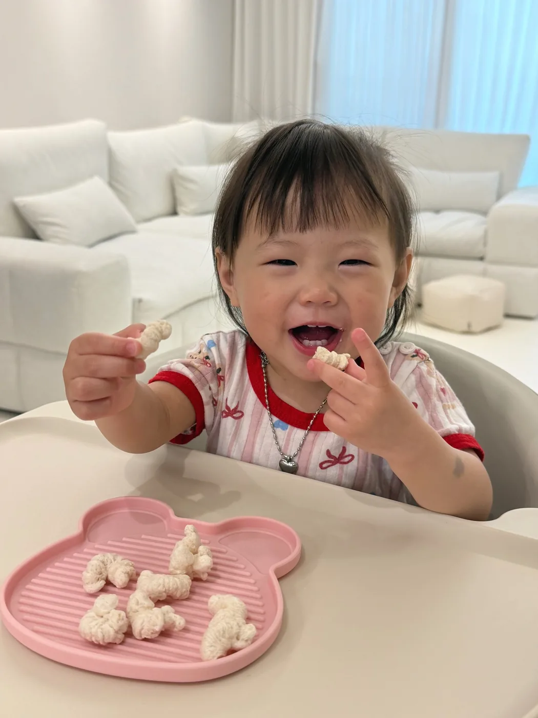 A baby picking up Tongtong Snack